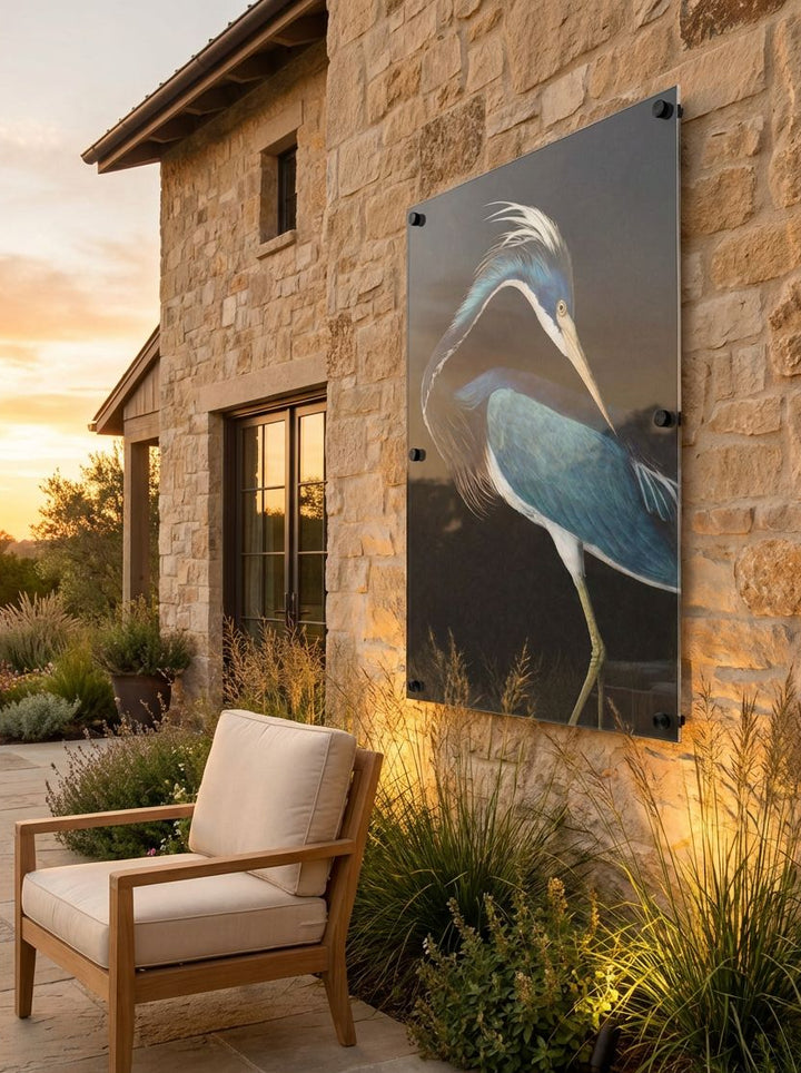 Chair by a stone building with a decorative metal panel featuring a bird design.
