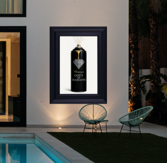 Framed artwork of a black bottle with gold accents on a white background, displayed in an indoor setting.