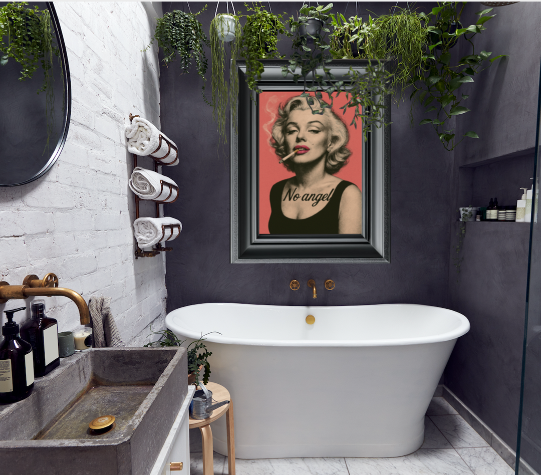 Bathroom with white bathtub, framed picture of Marilyn Monroe, and greenery.