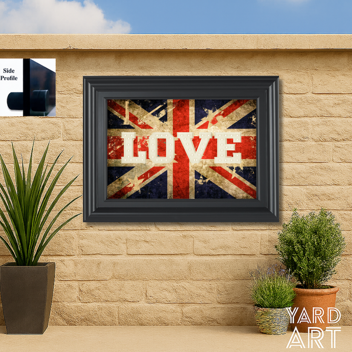 Framed Union Jack with 'LOVE' text on a stone wall with plants