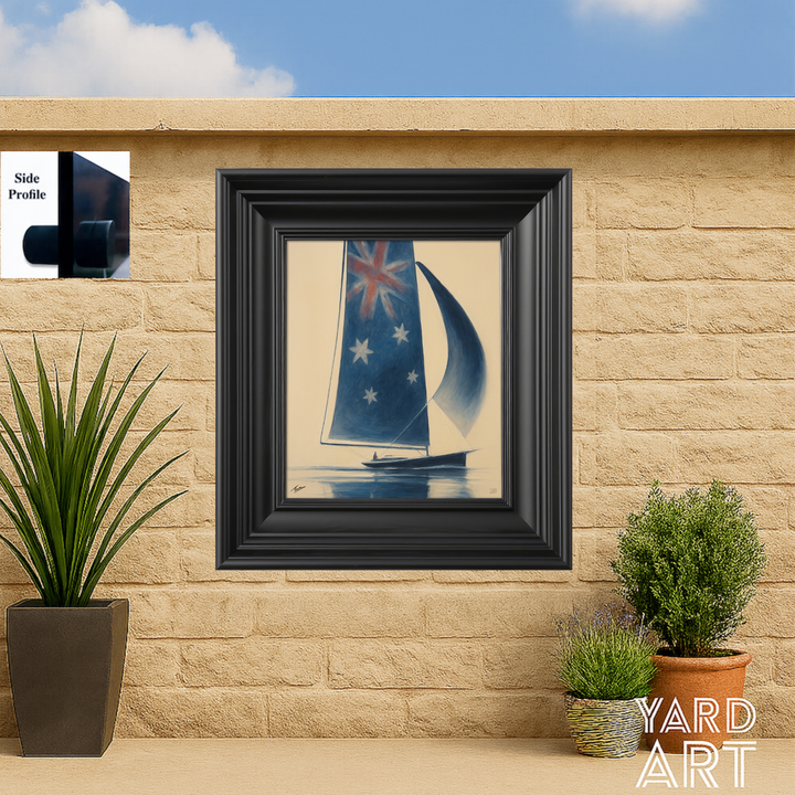 Framed artwork of a sailboat with a blue sail on a beige wall with plants.