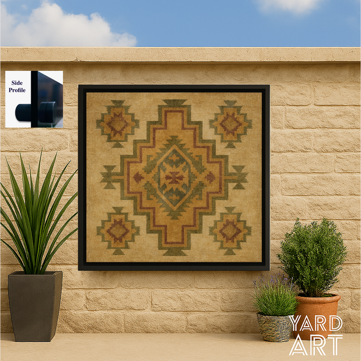 Framed geometric patterned artwork on a stone wall with plants and blue sky.