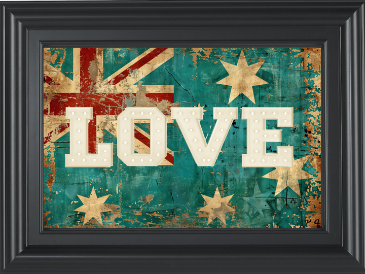 A person standing in front of a green brick wall with an acrylic print that features the word 'LOVE' in bold letters on a weathered flag background, framed in a black frame.